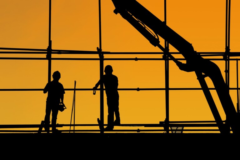 two construction workers working on scaffolding