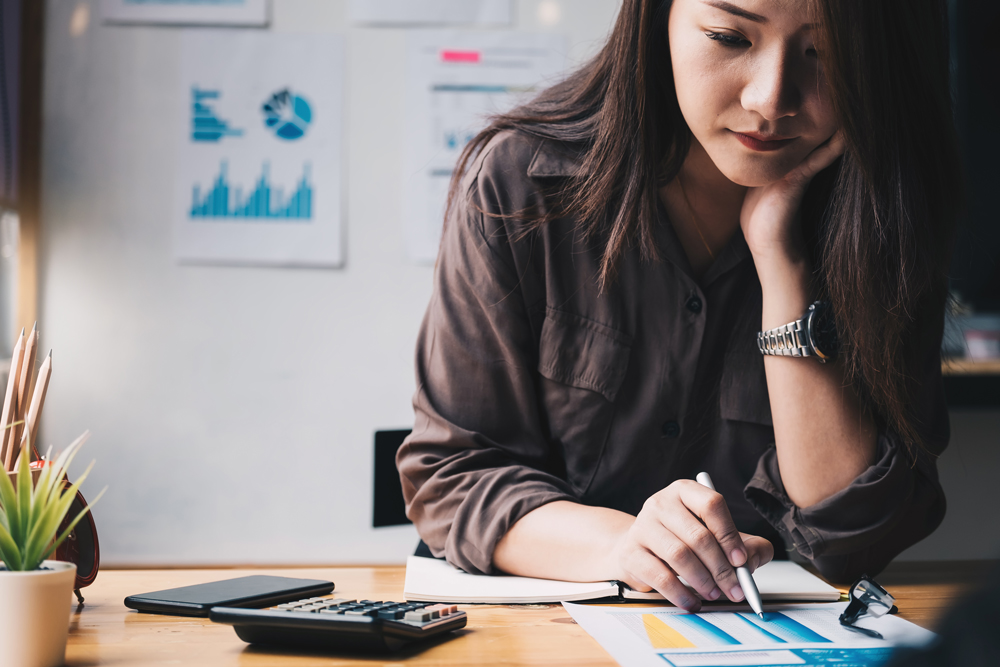 Business woman using calculator for do math finance on wooden desk in office and business working background